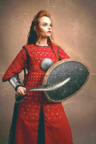 Medieval warrior woman with sword and shield, and big hair.